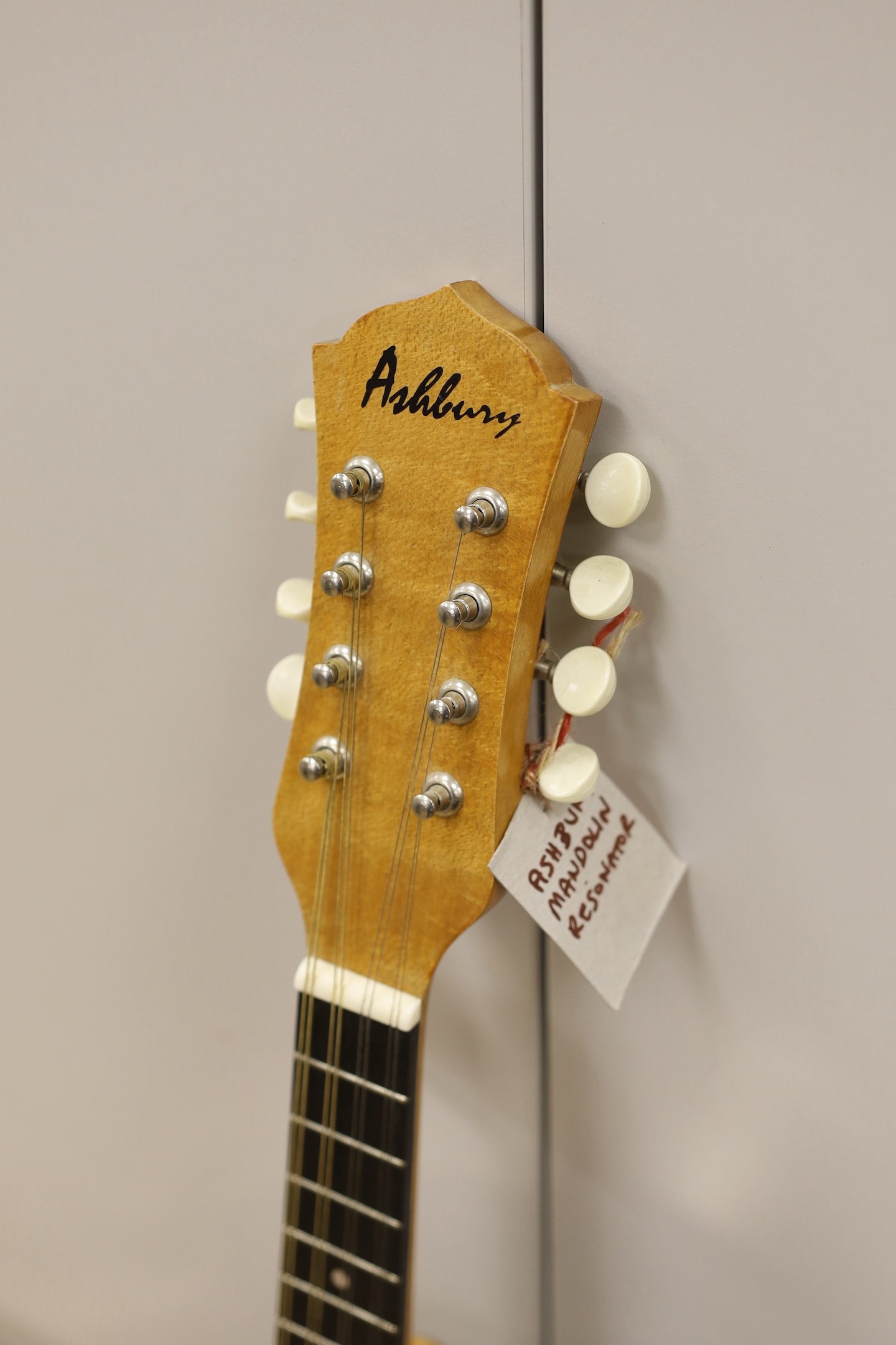 An Ashbury mandolin ‘Resonator’ with fitted, padded case, mandolin 69 cms high.
